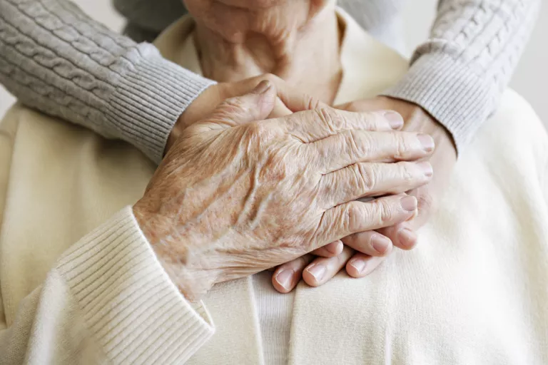 mains entremêlées sur la poitrine d'une vieille femme